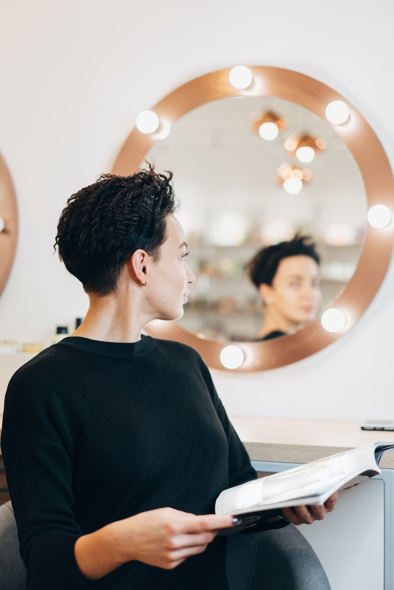 Attractive woman at the mirror in beauty studio